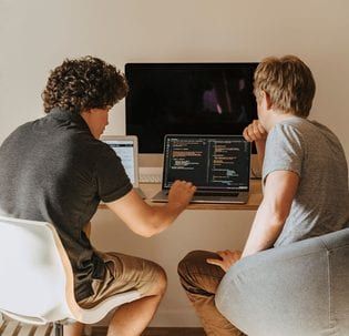 Engineers pairing on a line-of-business system at a shared workstation